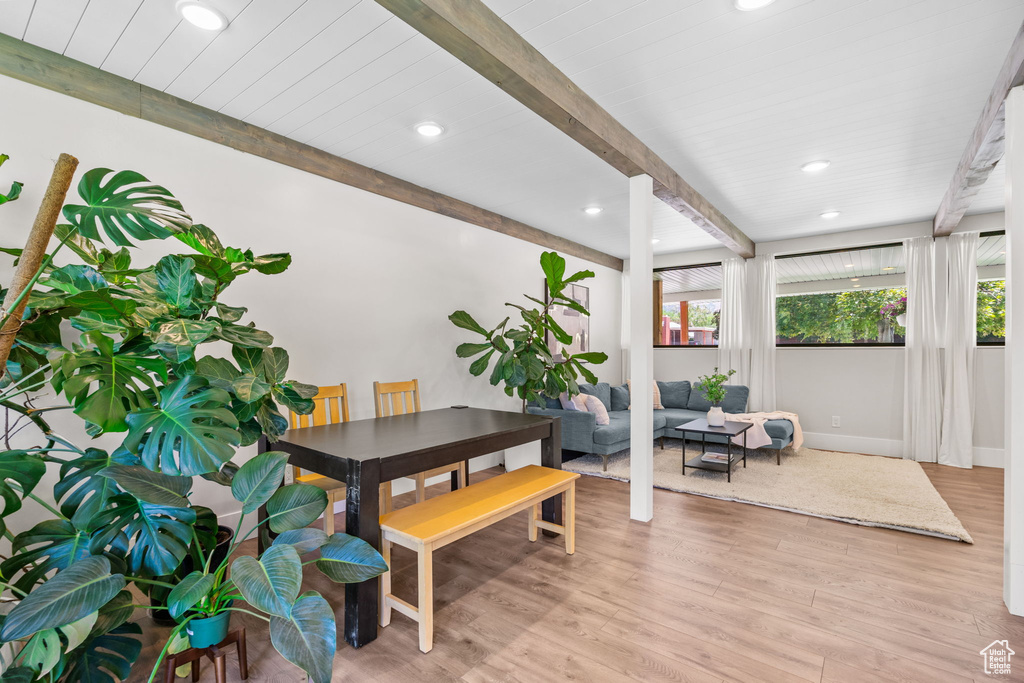 Dining space with beamed ceiling, light wood-style flooring, recessed lighting, and baseboards