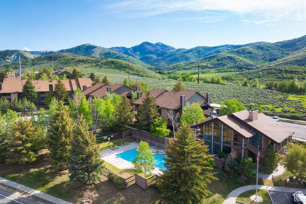 Aerial view of residential area featuring a pool area and a mountainous background