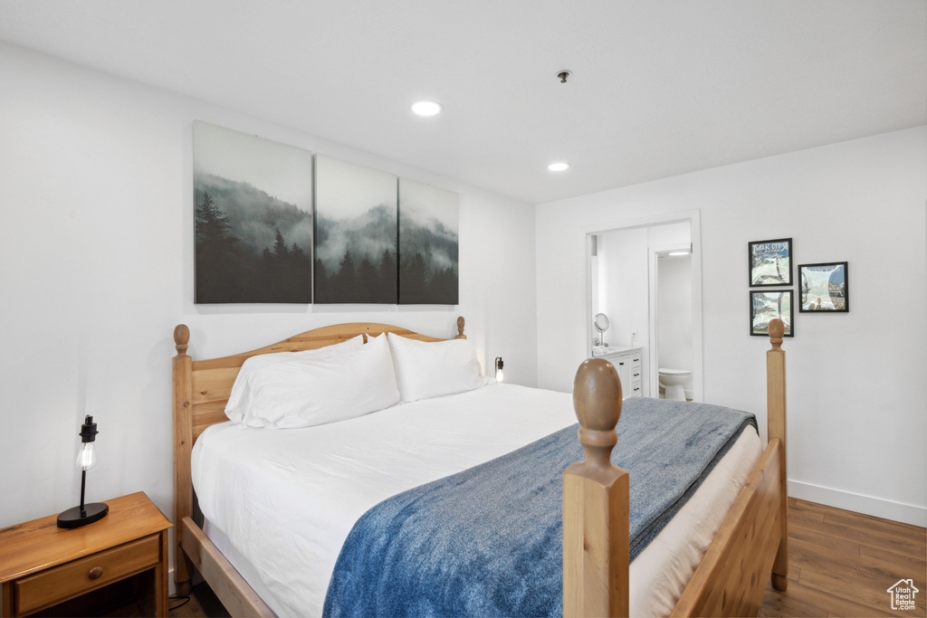 Bedroom with wood finished floors, recessed lighting, baseboards, and connected bathroom