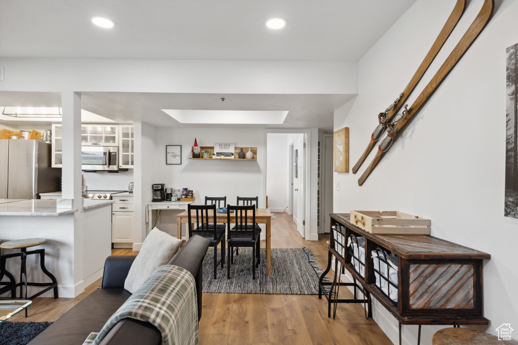 Dining room featuring light wood finished floors, recessed lighting, and a skylight