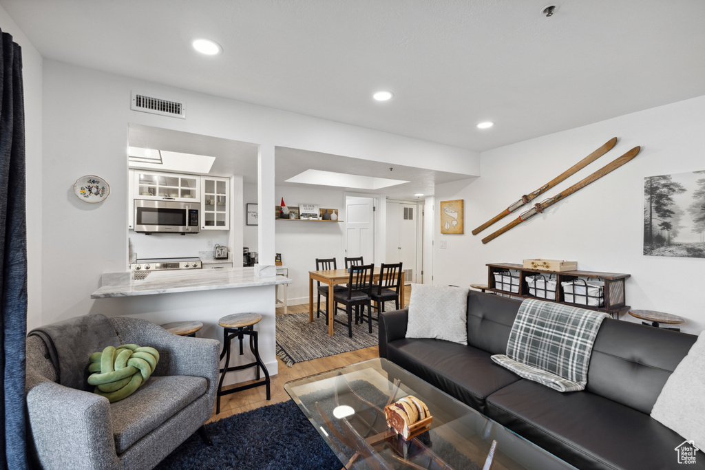 Living room with light wood finished floors and recessed lighting