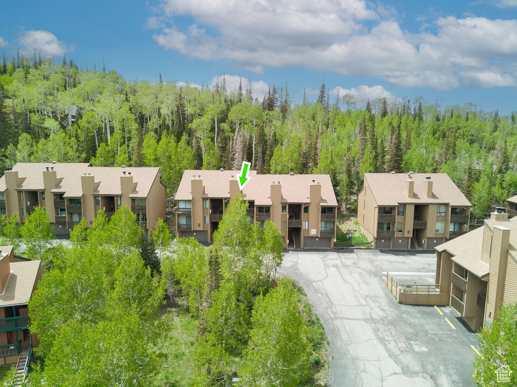 View of front of house featuring a residential view, a wooded view, and stucco siding