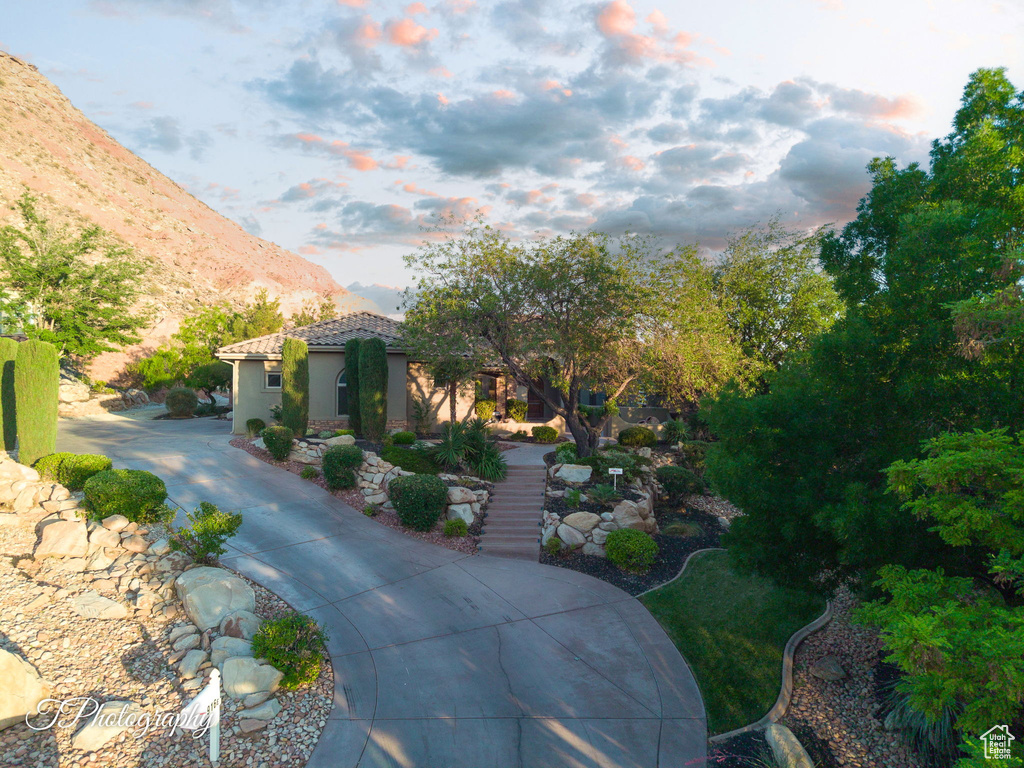 Mediterranean / spanish-style home featuring a mountain view, a tiled roof, stairs, and stucco siding