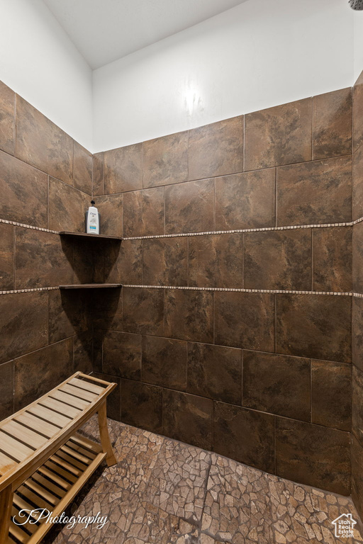 Bathroom with stone finish floors and tiled shower