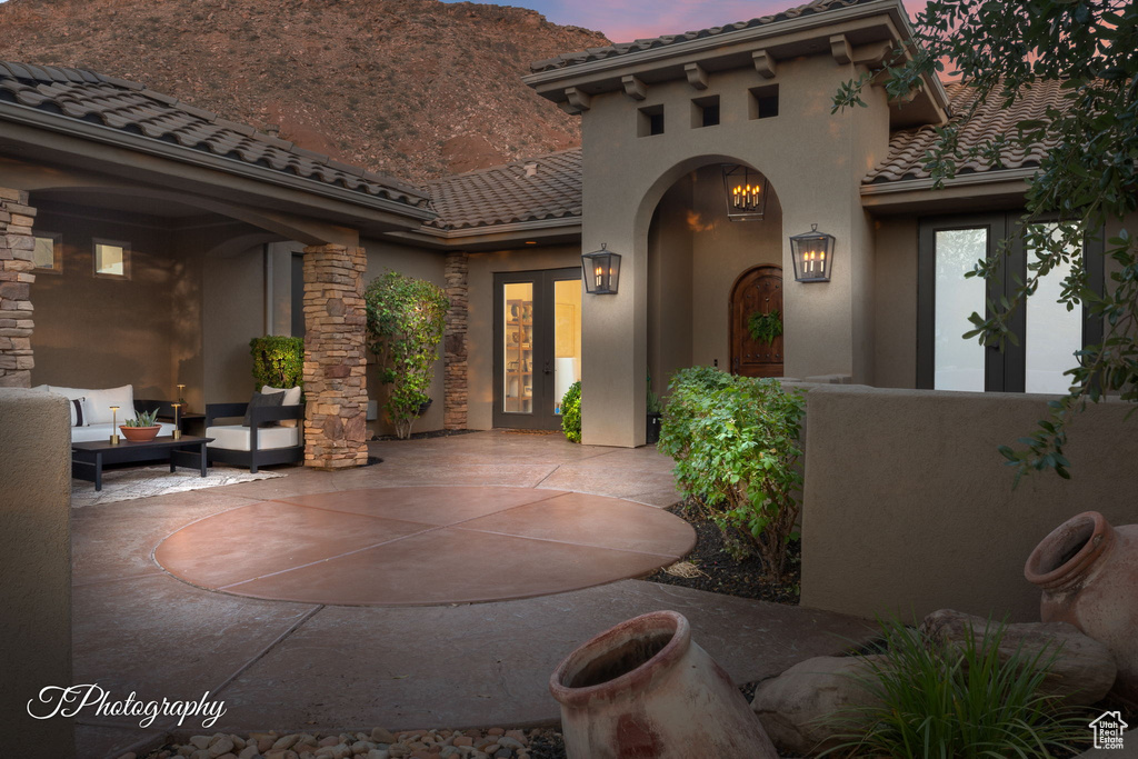 Patio terrace at dusk featuring french doors, a patio area, and outdoor lounge area