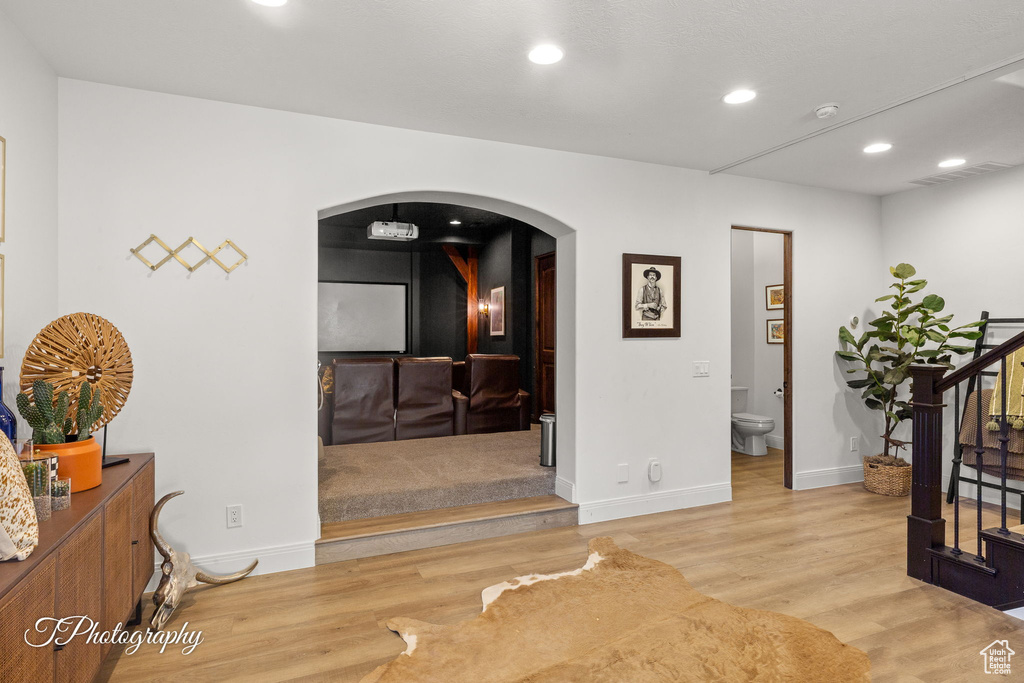 Corridor featuring arched walkways, stairway, wood finished floors, recessed lighting, and baseboards