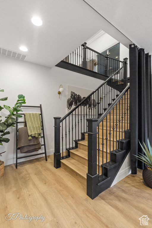 Stairs featuring wood finished floors, baseboards, and recessed lighting