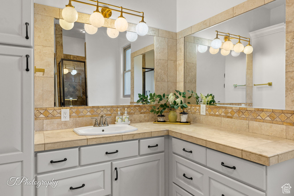 Bathroom with tasteful backsplash, vanity, and a stall shower