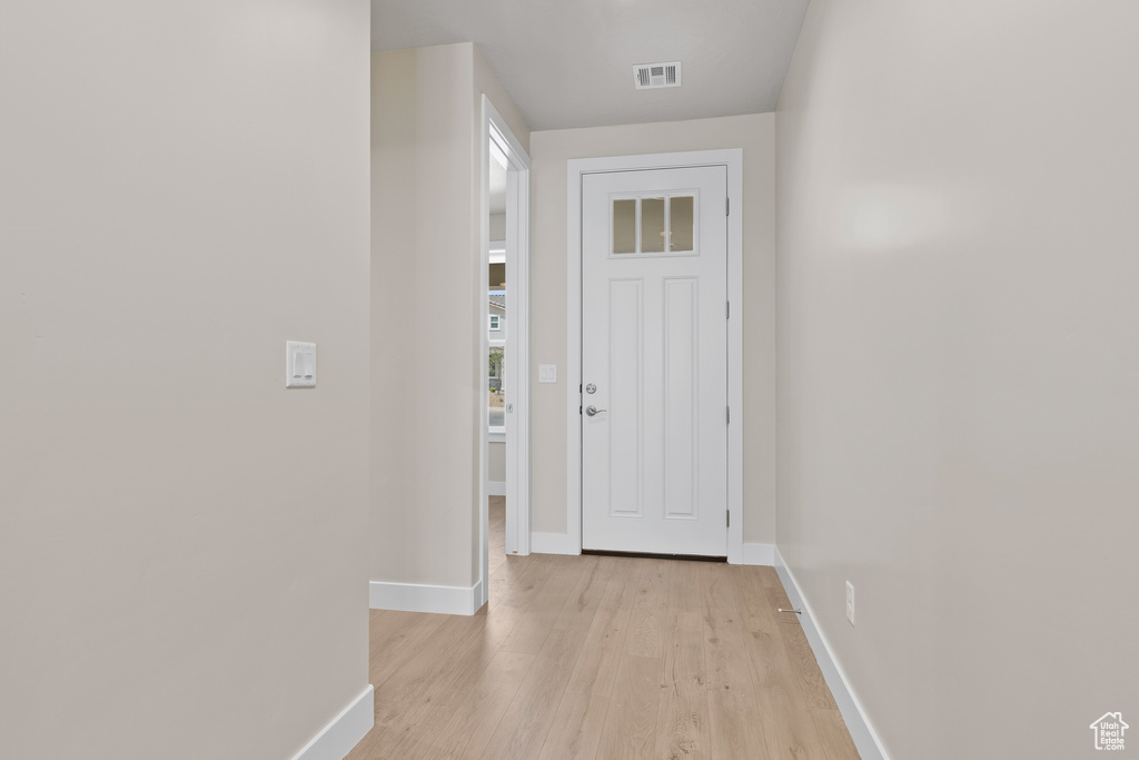 Doorway to outside featuring baseboards and light wood-style flooring