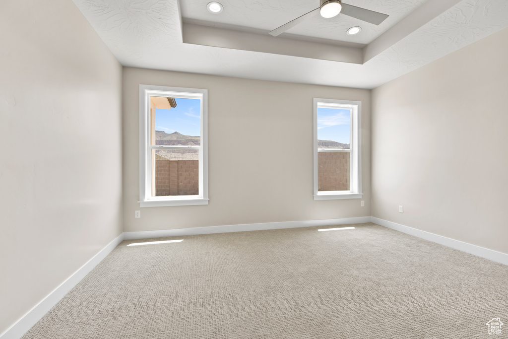 Unfurnished room featuring a tray ceiling, a ceiling fan, carpet, baseboards, and recessed lighting