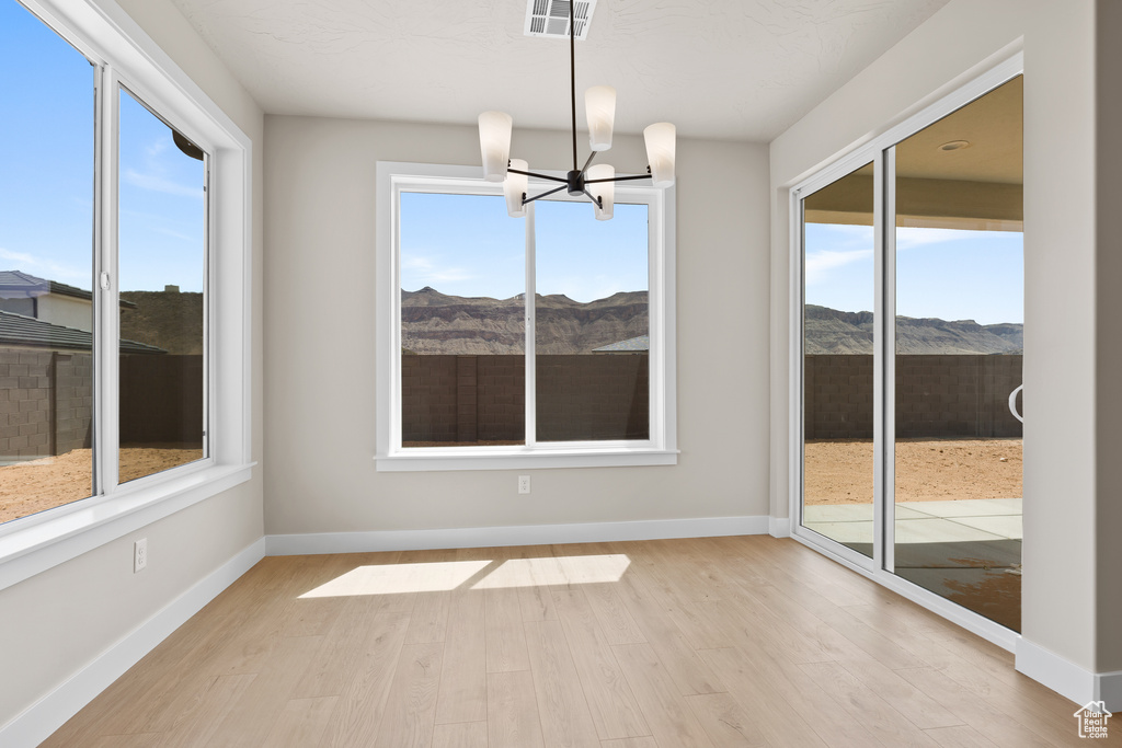 Unfurnished sunroom with a chandelier and a mountain view