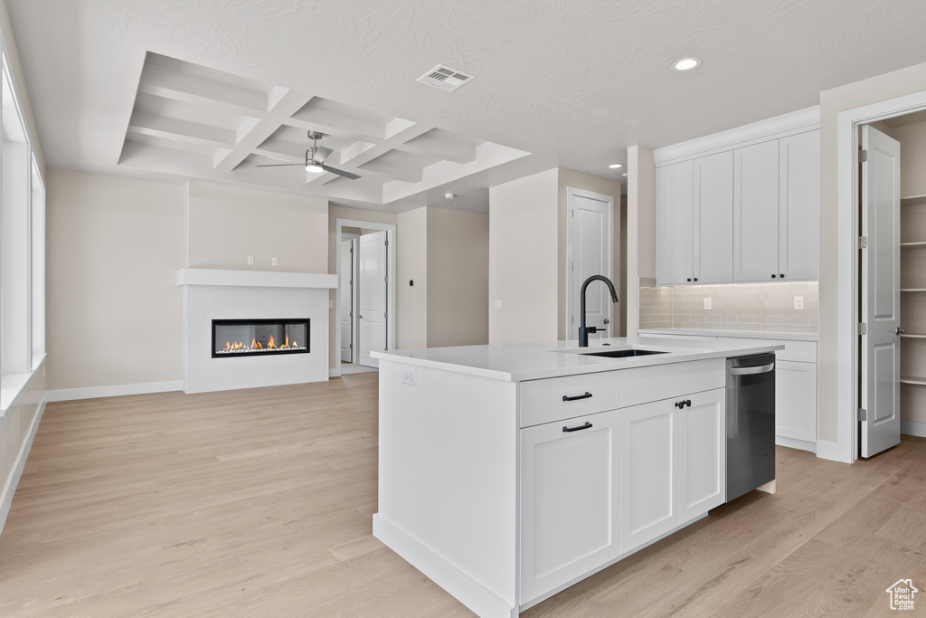 Kitchen with a sink, stainless steel dishwasher, coffered ceiling, recessed lighting, and light wood finished floors