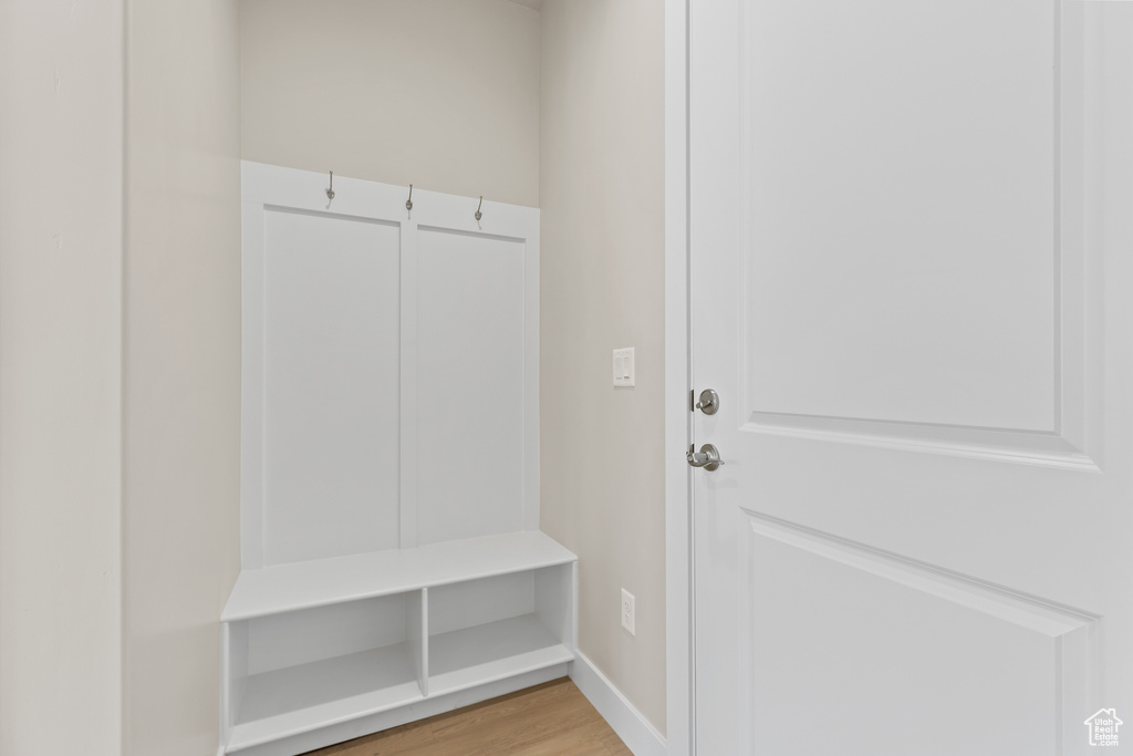 Mudroom featuring light wood finished floors and baseboards