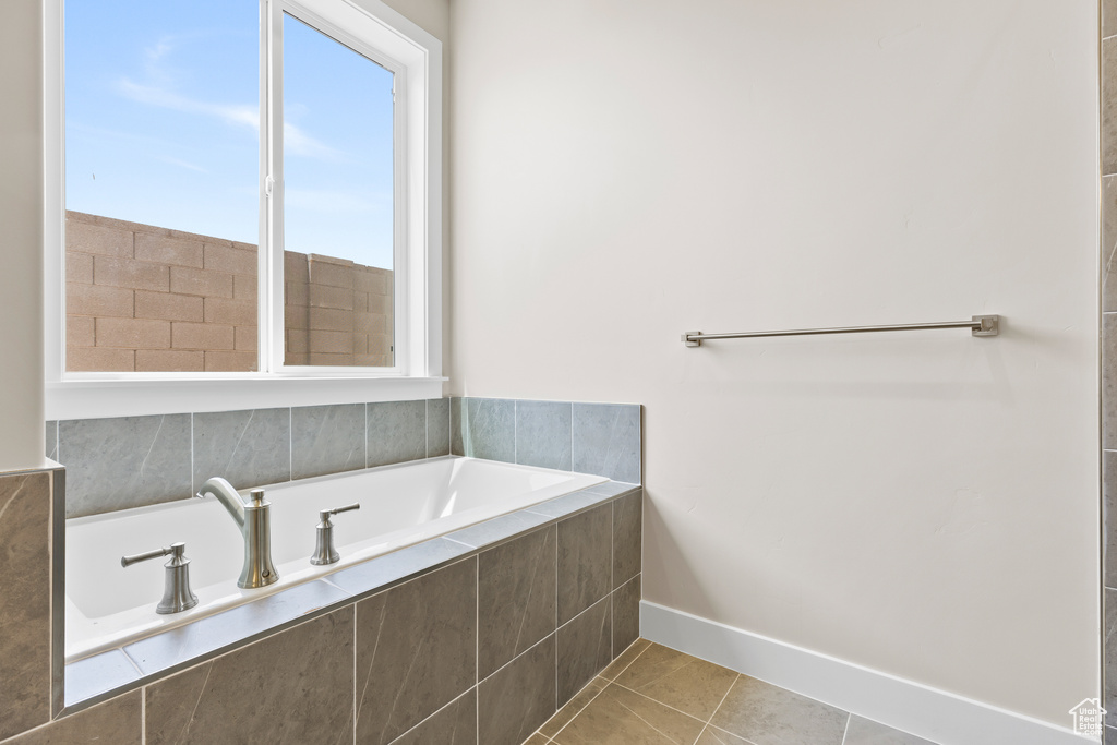 Full bath with a garden tub, tile patterned flooring, and baseboards