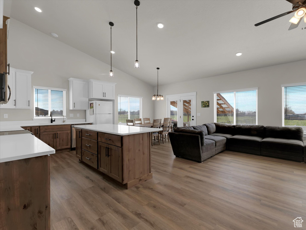 Kitchen featuring freestanding refrigerator, open floor plan, a ceiling fan, wood finished floors, and recessed lighting