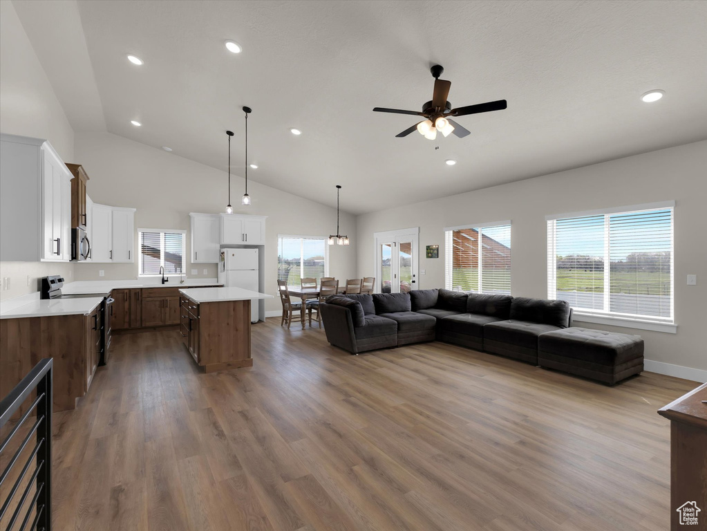 Living room with wood finished floors, ceiling fan, plenty of natural light, recessed lighting, and baseboards