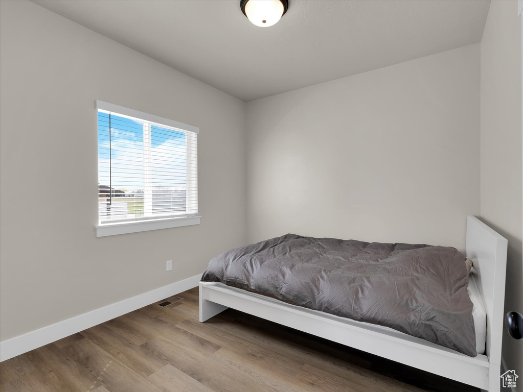 Bedroom featuring baseboards and wood finished floors