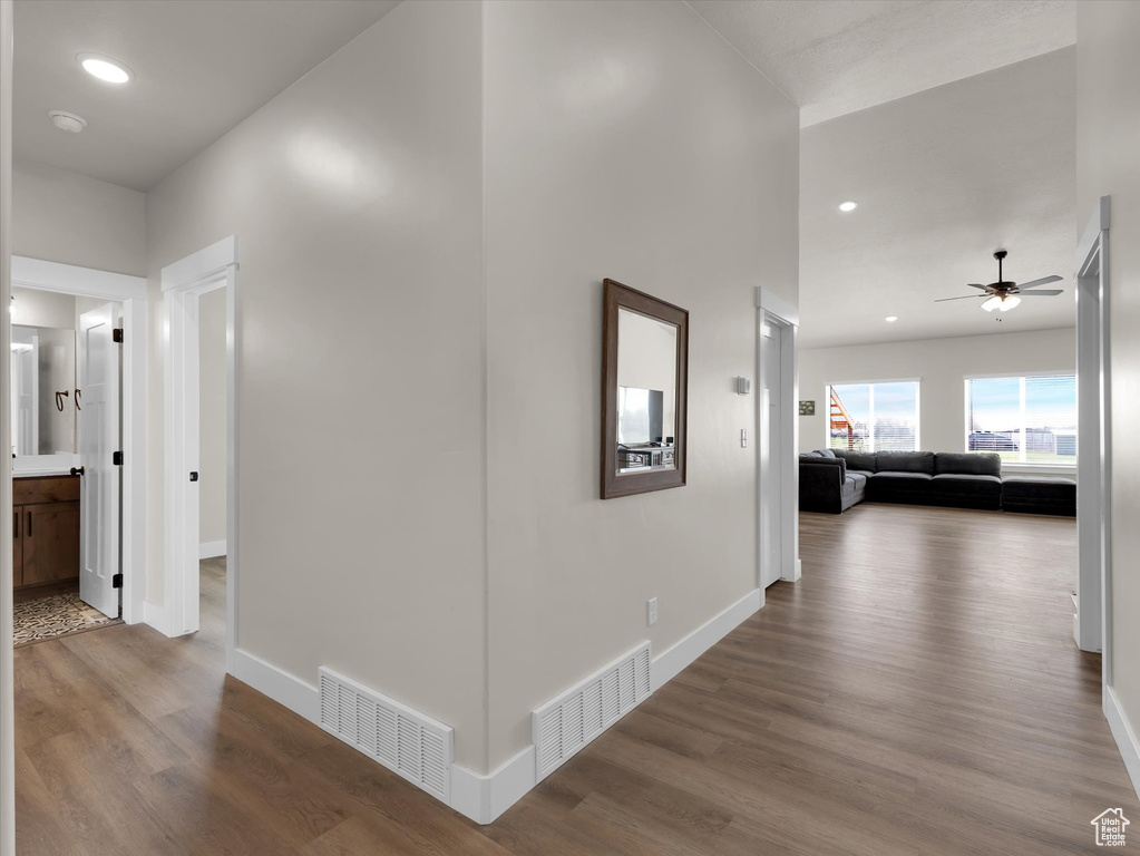 Hallway featuring wood finished floors, baseboards, and recessed lighting