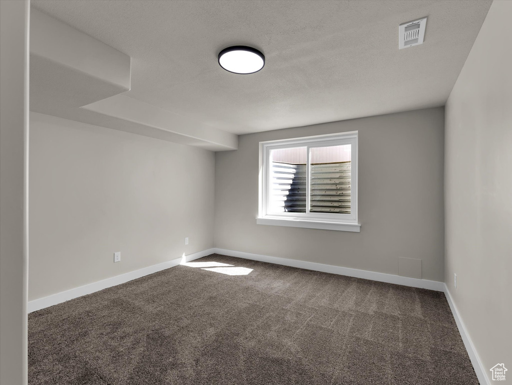Empty room featuring carpet and baseboards