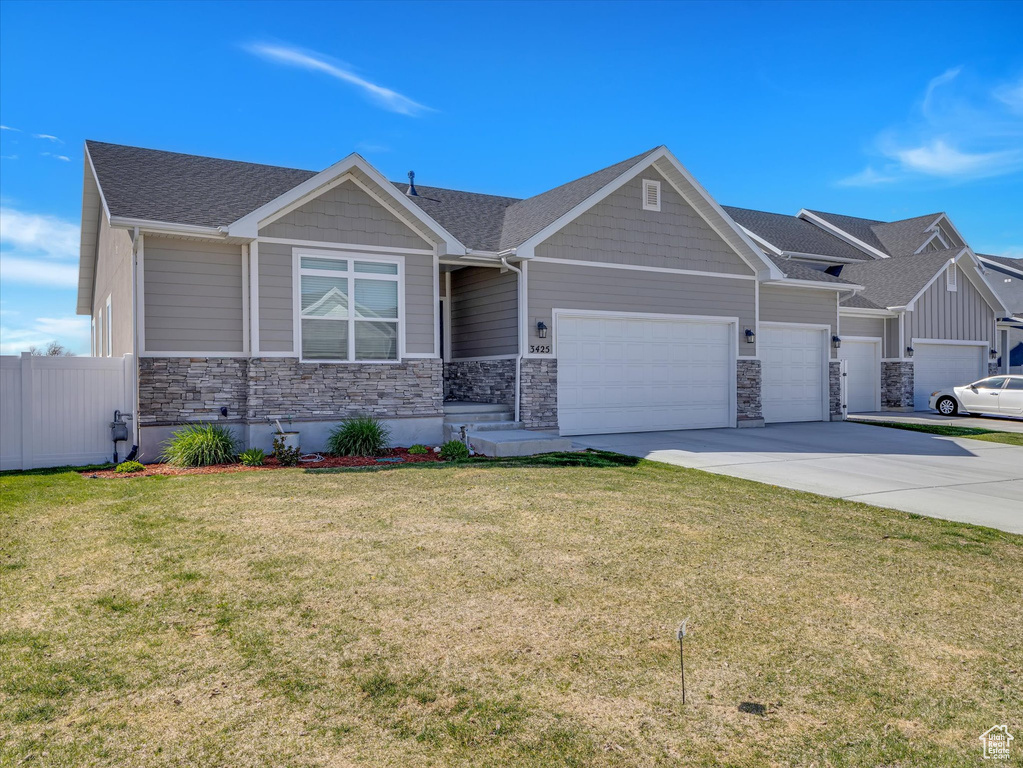 Craftsman house with a garage, driveway, stone siding, and roof with shingles