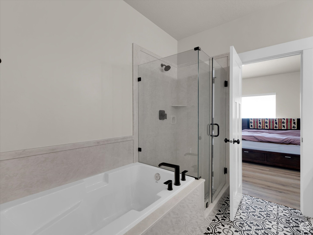 Ensuite bathroom featuring a stall shower, a bath, and tile patterned flooring