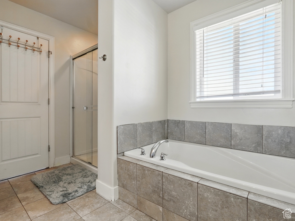 Bathroom with a garden tub, a shower stall, and tile patterned flooring