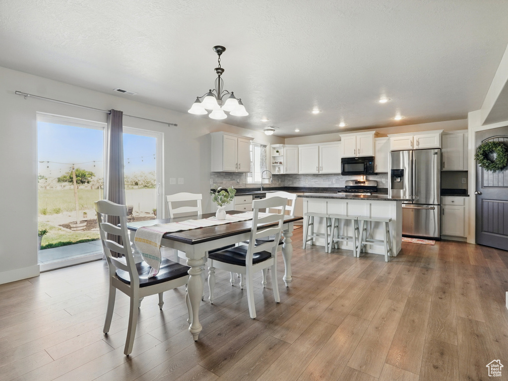 Dining room featuring wood finished floors, a chandelier, and recessed lighting