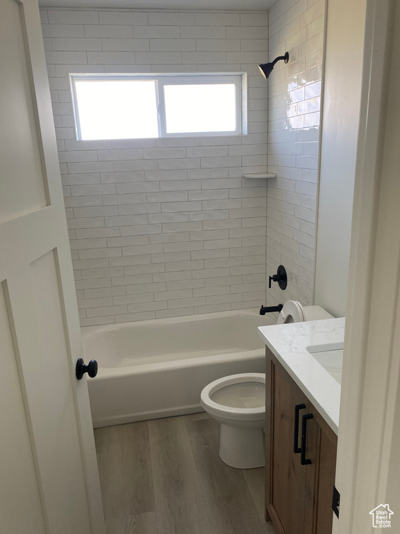 Full bath featuring toilet, wood finished floors, vanity, and bathing tub / shower combination