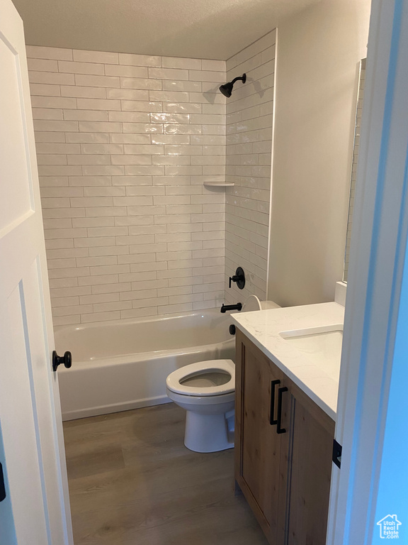 Full bathroom featuring wood finished floors, toilet, vanity, and shower / bath combination