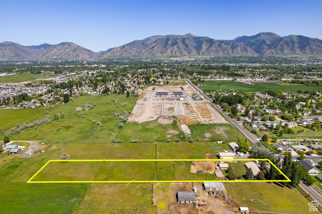 Aerial view of residential area with a mountainous background and property parcel outlined