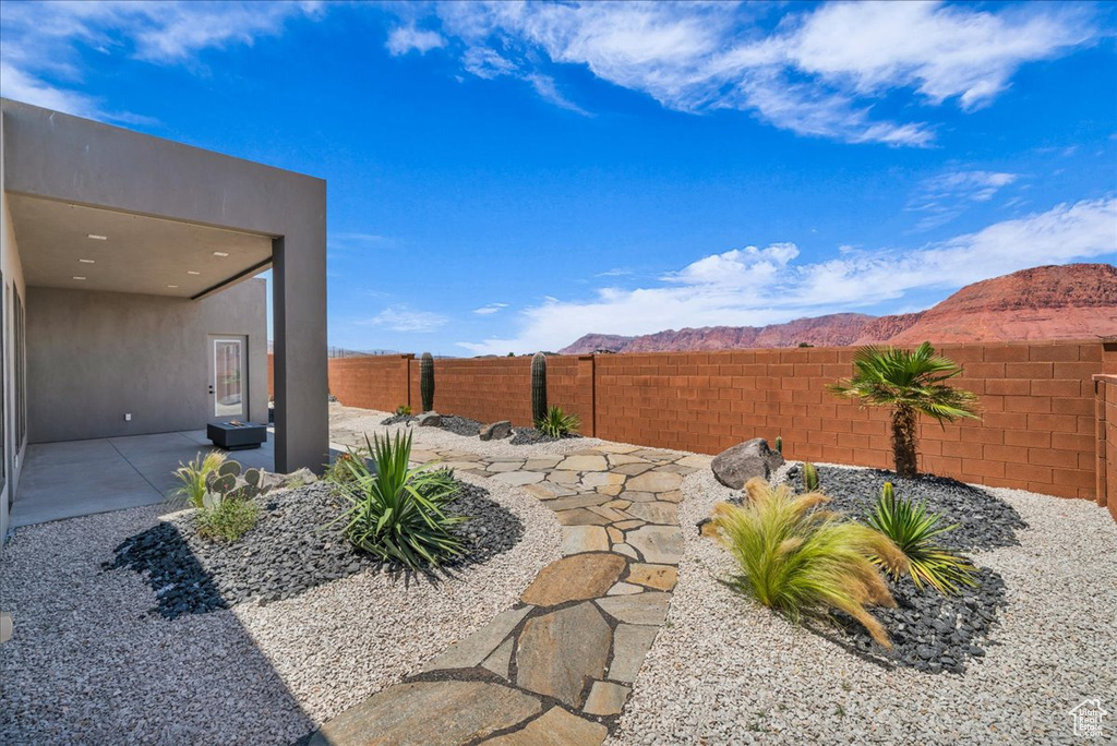 Fenced backyard featuring a patio and a mountain view