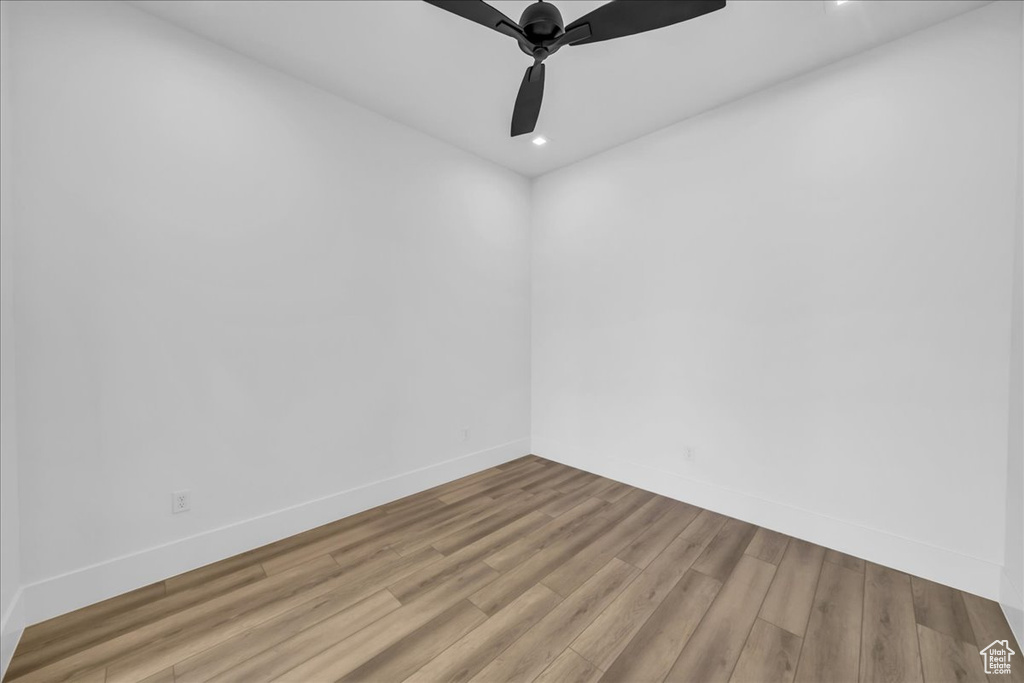 Unfurnished room with wood finished floors, a ceiling fan, recessed lighting, and baseboards