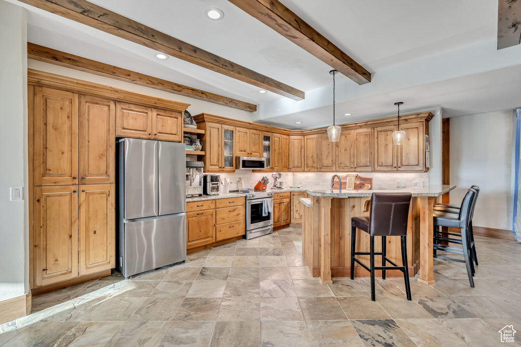 Kitchen featuring stainless steel appliances, a breakfast bar, backsplash, pendant lighting, and beam ceiling