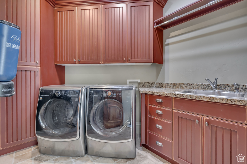 Laundry area featuring cabinet space and washer and clothes dryer