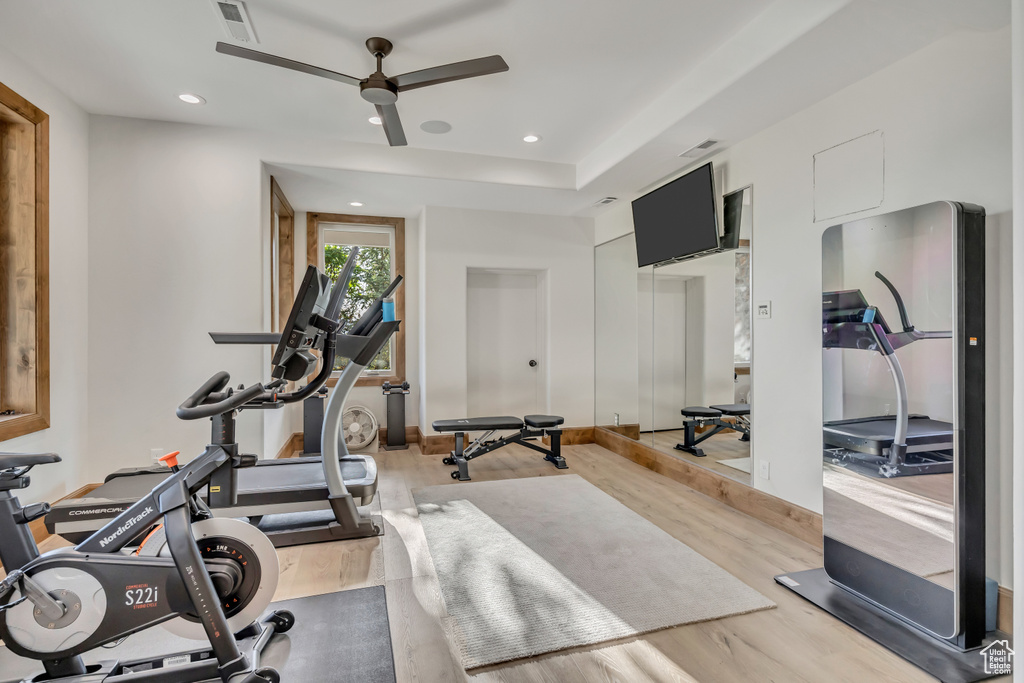 Exercise area with ceiling fan, light wood finished floors, and recessed lighting