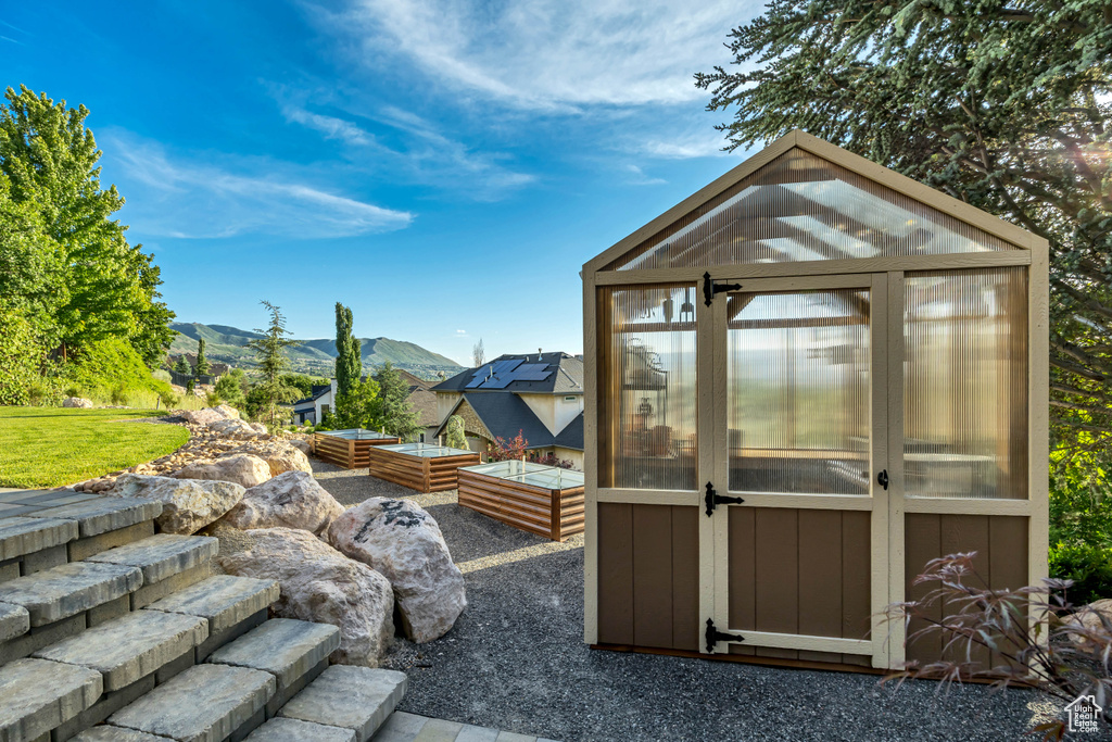 View of greenhouse featuring a mountain view and a garden