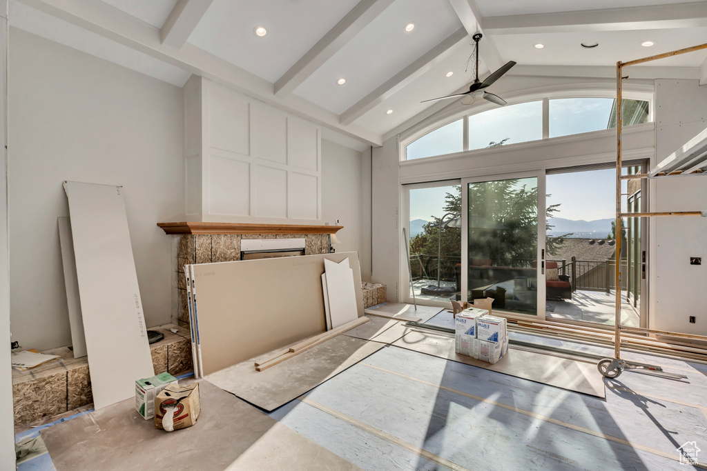 Unfurnished living room with a fireplace, beamed ceiling, recessed lighting, high vaulted ceiling, and a ceiling fan