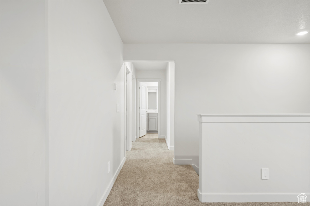 Hallway with carpet and baseboards