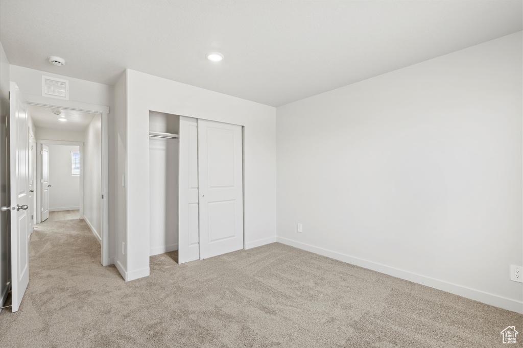 Unfurnished bedroom with carpet, a closet, and recessed lighting