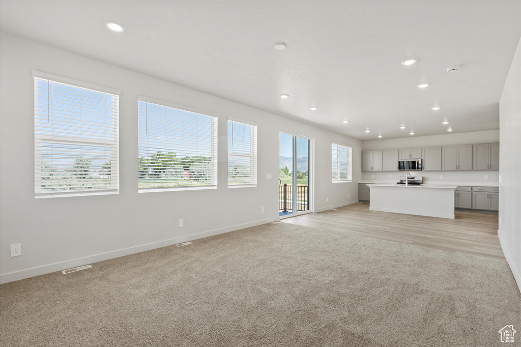 Unfurnished living room featuring light colored carpet and recessed lighting