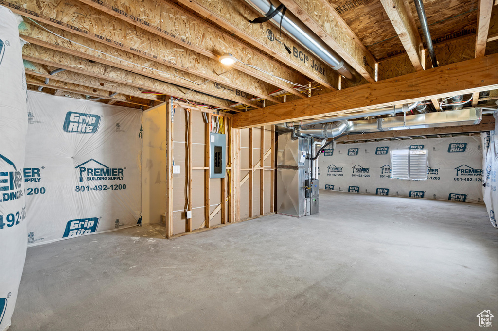 Below grade area featuring electric panel and heating unit