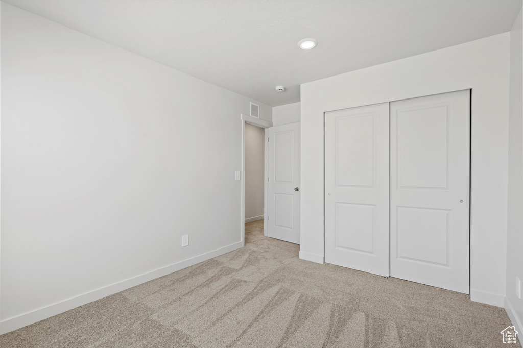 Unfurnished bedroom featuring carpet flooring, a closet, and recessed lighting