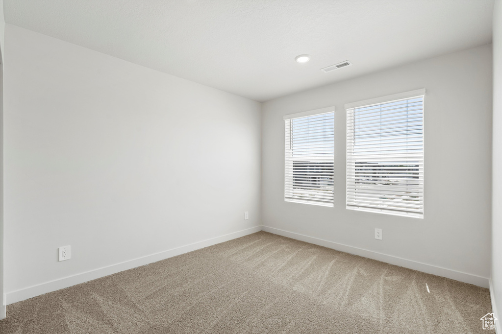 Carpeted spare room with baseboards