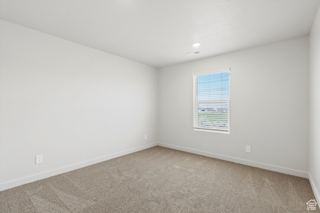 Carpeted spare room with baseboards and recessed lighting