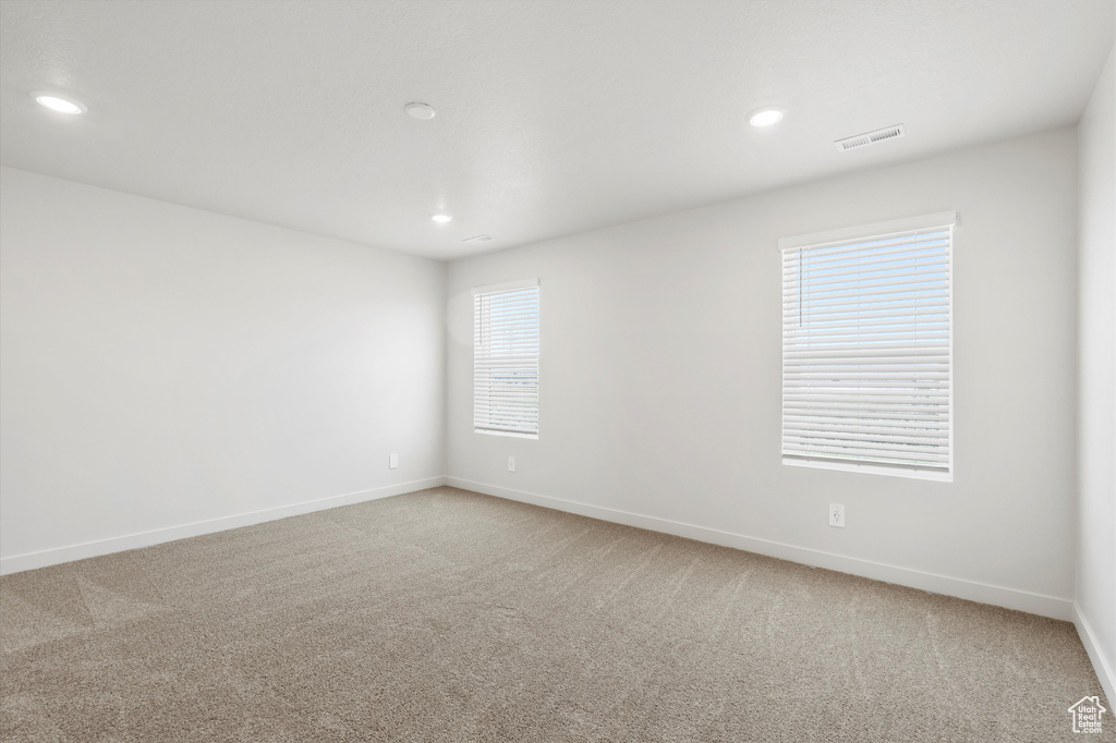 Empty room featuring light colored carpet and recessed lighting