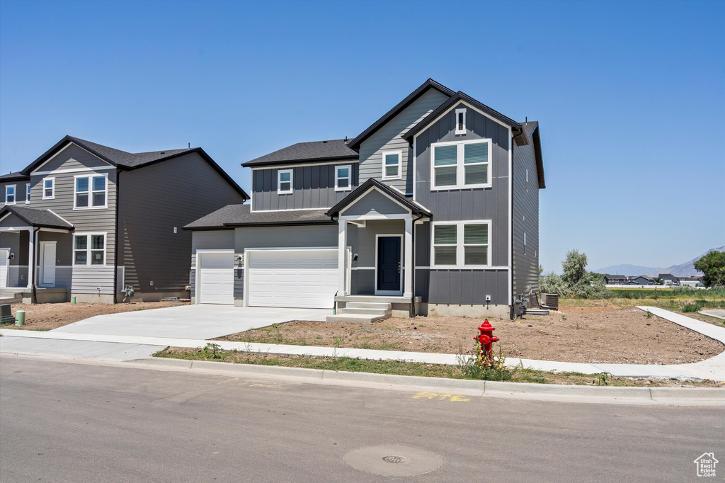 Traditional-style home with board and batten siding, concrete driveway, and an attached garage