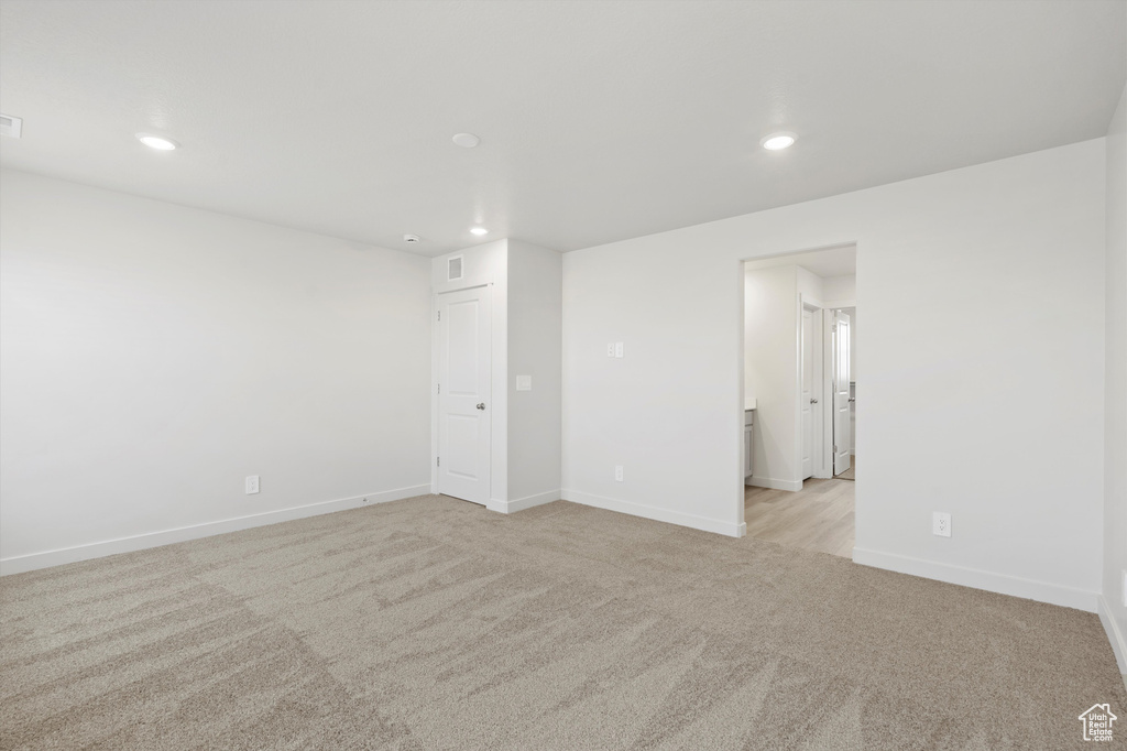 Empty room featuring light colored carpet and recessed lighting