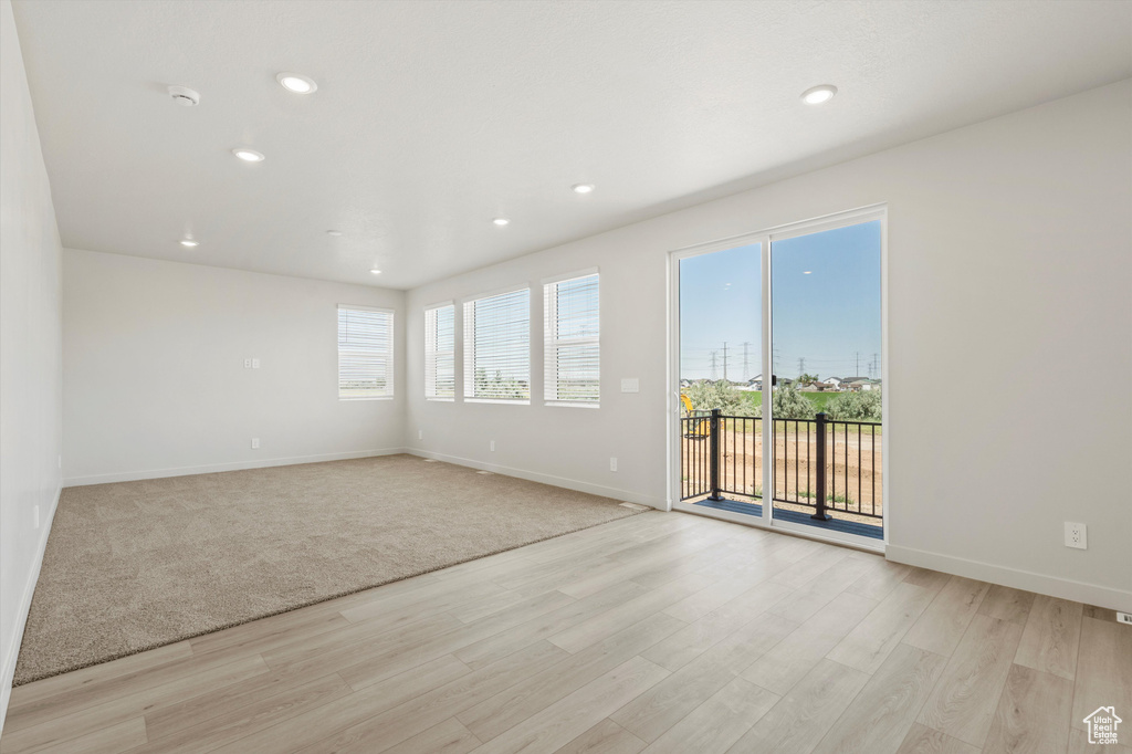 Empty room featuring light wood-style flooring, recessed lighting, and a smoke detector