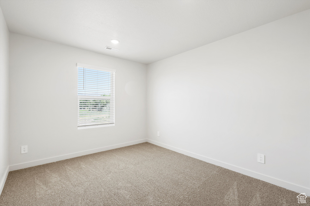 Carpeted spare room with baseboards