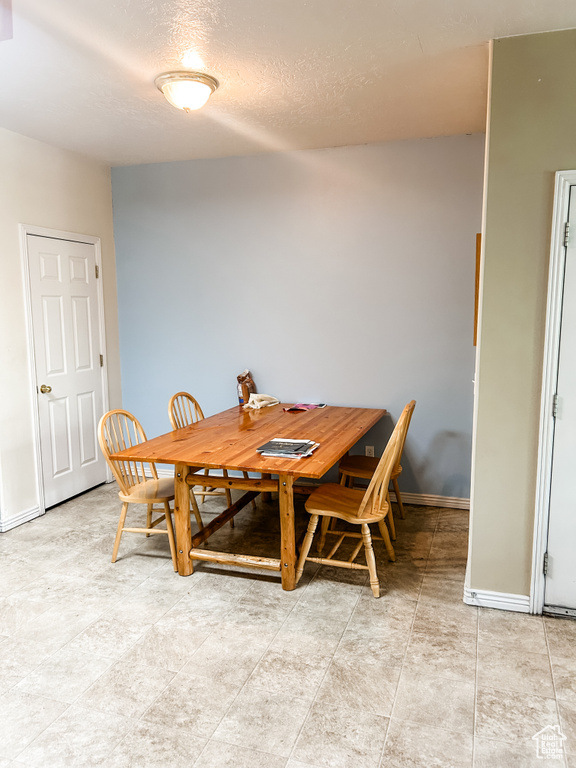 Dining room featuring baseboards and a textured ceiling